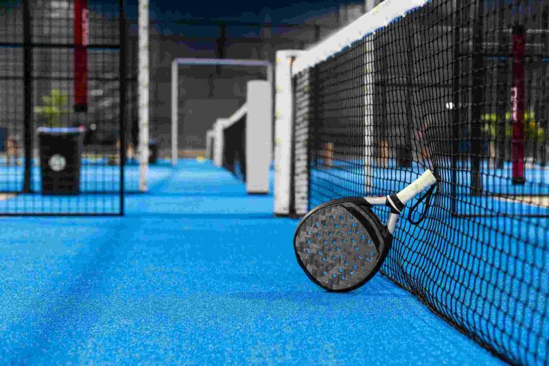 Padel racket leant on padel net